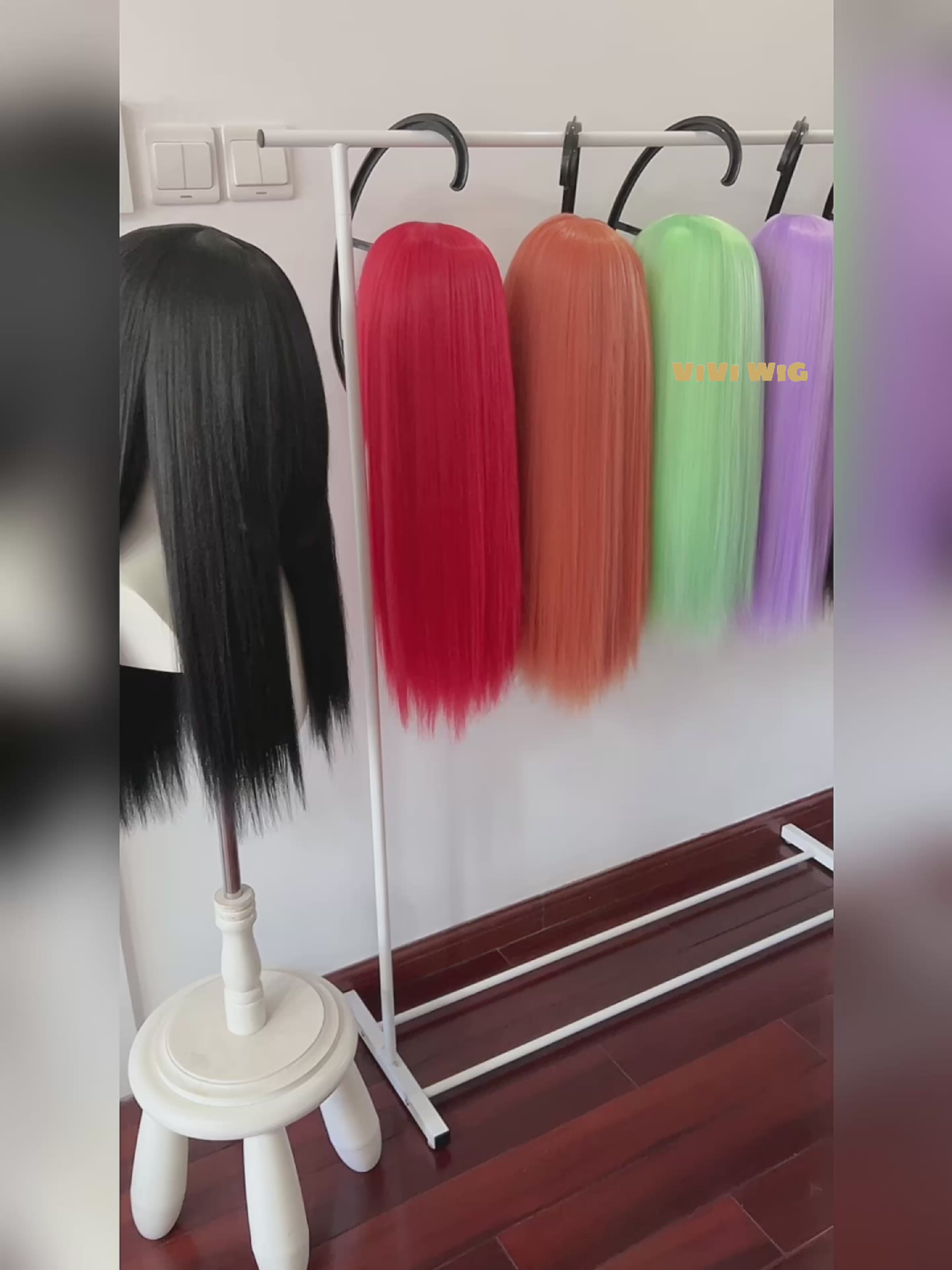 Display of medium cosplay wigs in various colors, including black, red, orange, and yellow on a wig stand.